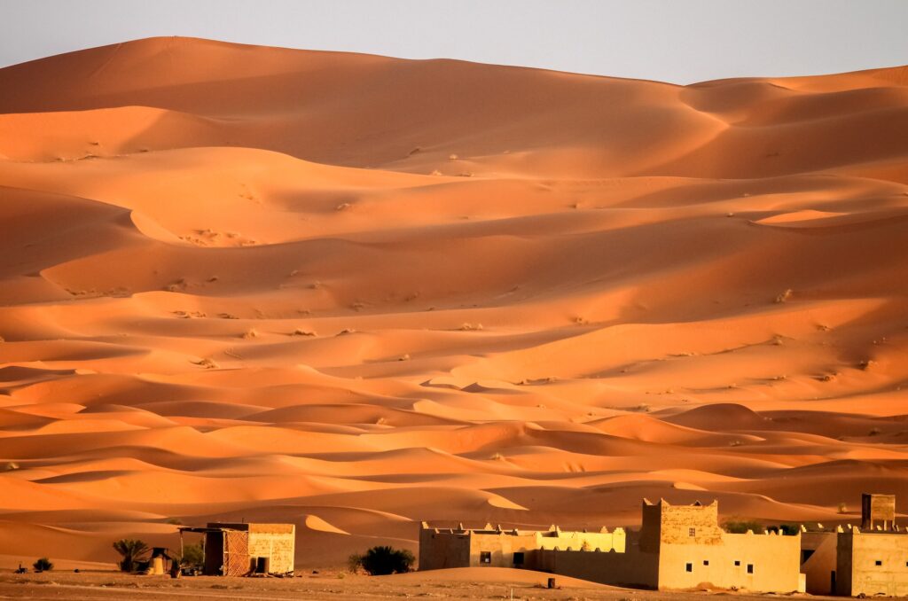 Berber homes at the foot of stunning sand dunes of Merzouga