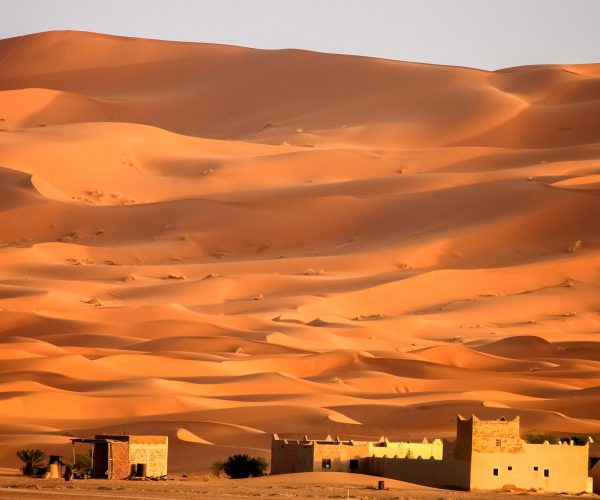 Berber homes at the foot of stunning sand dunes of Merzouga